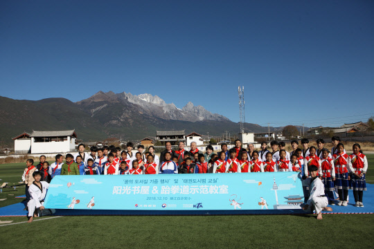 꿈의 도서실 기증 행사 관계자와 바이사 소학교 학생, 국가대표 태권도시범단이 기념 촬영을 하고 있는 모습. <대한항공 제공>